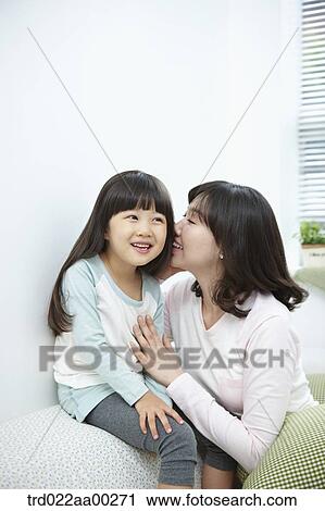 The woman whispering in girl's ear View Large Photo Image Stock Image - The woman whispering in girl's ear. Fotosearch