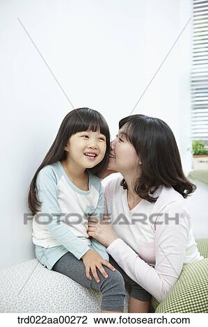 The woman whispering in girl's ear View Large Photo Image Stock Image - The woman whispering in girl's ear. Fotosearch