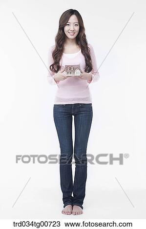 Stock Image - The woman with house model. Fotosearch