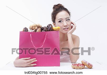 The woman with the bag of doughnut View Large Photo Image Stock Photography - The woman with the bag of doughnut. Fotosearch