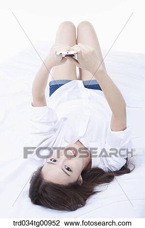 The woman with the phone on the bed View Large Photo Image Stock Image - The woman with the phone on the bed. Fotosearch