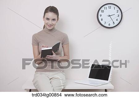 The woman writing on planner on the desk View Large Photo Image Picture - The woman writing on planner on the desk. Fotosearch