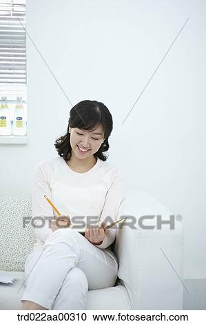 The woman writing on the notebook with the pencil View Large Photo Image Stock Image - The woman writing on the notebook with the pencil. Fotosearch