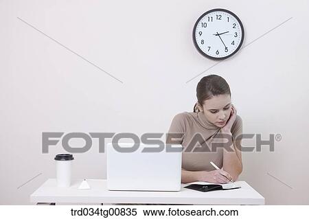 The woman writing on the planner in the office View Large Photo Image Stock Photography - The woman writing on the planner in the office. Fotosearch