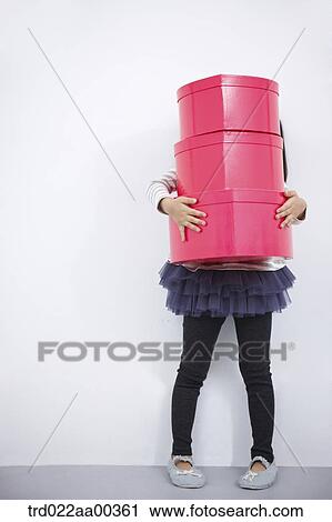 Stock Image - A girl holding red heart box. Fotosearch