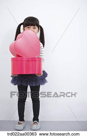 A girl holding red heart box View Large Photo Image Stock Image - A girl holding red heart box. Fotosearch