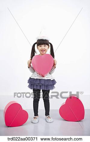 Stock Image - A girl holding red heart box. Fotosearch