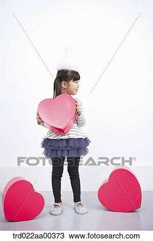 Stock Image - A girl holding red heart box. Fotosearch