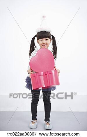 Stock Photo - A girl holding red heart box. Fotosearch