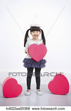 Stock Photo - A girl holding red heart box. Fotosearch
