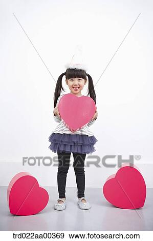A girl holding red heart box View Large Photo Image Stock Photo - A girl holding red heart box. Fotosearch