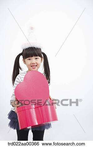 Stock Photograph - A girl holding red heart box. Fotosearch