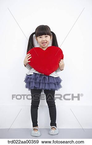 Stock Photo - A girl holding red heart . Fotosearch