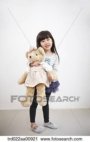 Stock Image - A girl holding teddy bear. Fotosearch