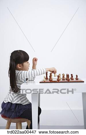 Stock Photo - A girl playing chess game . Fotosearch