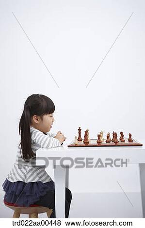 Stock Photo - A girl playing chess game . Fotosearch