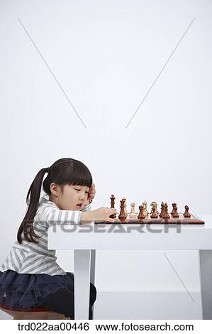 Stock Photograph - A girl playing chess game . Fotosearch