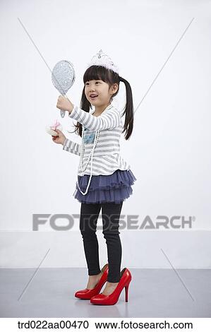 A girl putting on make up while looking at mirror View Large Photo Image Stock Image - A girl putting on make up while looking at mirror. Fotosearch