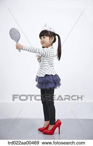 A girl putting on make up while looking at mirror View Large Photo Image Stock Photo - A girl putting on make up while looking at mirror. Fotosearch