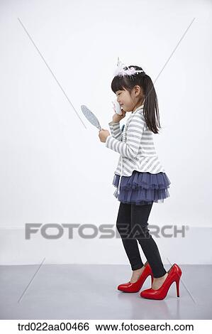 A girl putting on make up while looking at mirror View Large Photo Image Stock Photograph - A girl putting on make up while looking at mirror. Fotosearch