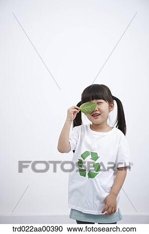 Stock Image - A girl wearing recycling shirt with green leaf. Fotosearch