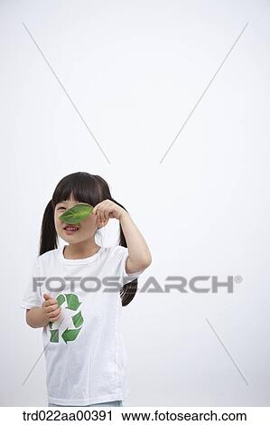 Stock Image - A girl wearing recycling shirt with green leaf. Fotosearch