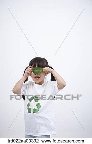 Stock Image - A girl wearing recycling shirt with green leaf. Fotosearch