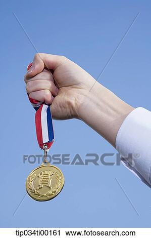 Stock Image - A hand holding the prize medal. Fotosearch