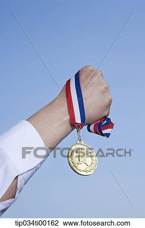 Stock Image - A hand holding the prize medal. Fotosearch