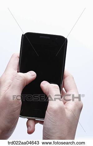 Stock Image - A hand touching on the Smartphone . Fotosearch