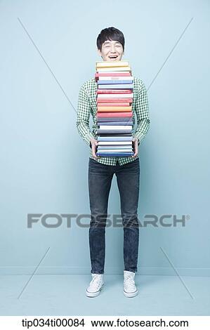 Picture - A man carrying the pile of books. Fotosearch