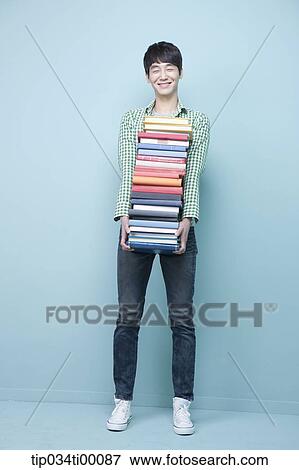 Stock Photo - A man carrying the pile of books. Fotosearch