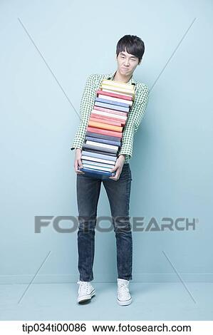 Stock Photograph - A man carrying the pile of books. Fotosearch