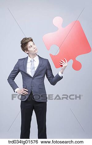 A man holding the big piece of red puzzle View Large Photo Image Stock Photograph - A man holding the big piece of red puzzle. Fotosearch