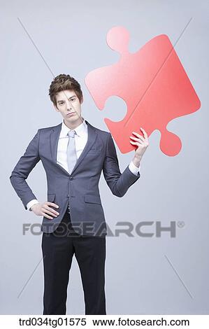 A man holding the big piece of red puzzle View Large Photo Image Stock Photography - A man holding the big piece of red puzzle. Fotosearch