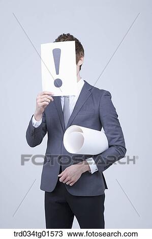 A man holding the exclamation mark over his face View Large Photo Image Stock Image - A man holding the exclamation mark over his face. Fotosearch