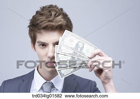 Stock Image - A man holding the money. Fotosearch