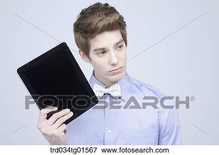 Stock Photo - A man holding the tablet PC. Fotosearch