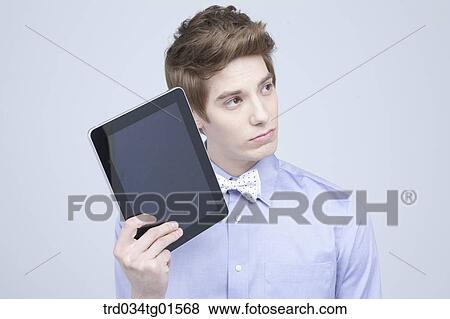 Stock Photo - A man holding the tablet PC. Fotosearch
