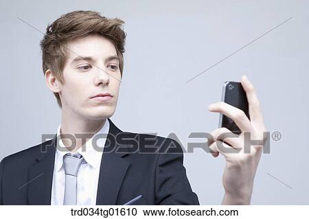 Stock Image - A man looking at the smart phone. Fotosearch