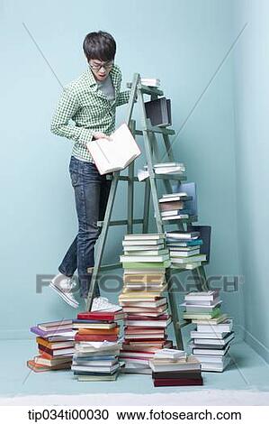 A man looking down on the piled books View Large Photo Image Stock Image - A man looking down on the piled books. Fotosearch
