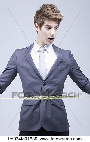 A man measuring his waist with tape measure View Large Photo Image Stock Image - A man measuring his waist with tape measure . Fotosearch