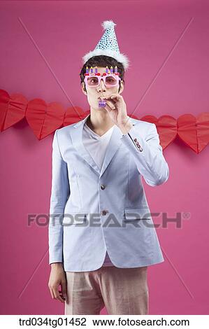 Stock Image - A man preparing the party event with pipe. Fotosearch