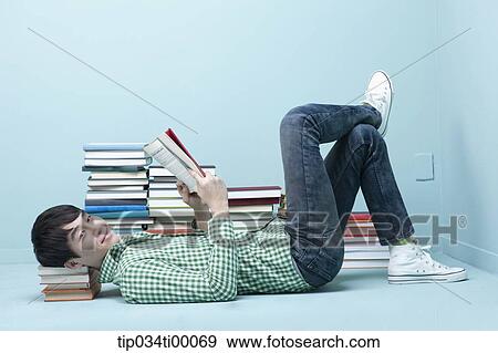 A man reading a book on the floor View Large Photo Image Stock Photo - A man reading a book on the floor. Fotosearch