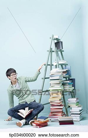 A man surprised at the height of the piled books View Large Photo Image Stock Image - A man surprised at the height of the piled books. Fotosearch