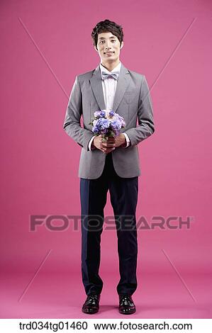 Stock Image - A man wearing formal suit with the flower. Fotosearch
