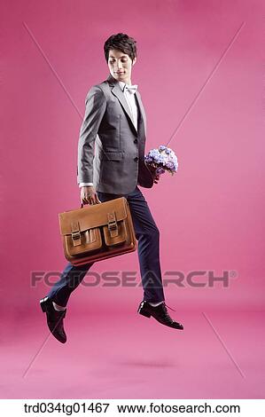 A man wearing formal suit with the flower and bag View Large Photo Image Stock Photo - A man wearing formal suit with the flower and bag. Fotosearch
