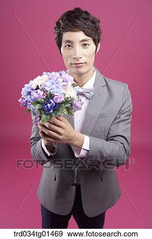 Stock Photo - A man wearing formal suit with the flower. Fotosearch