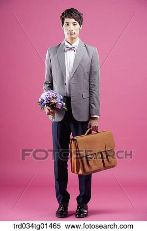 A man wearing formal suit with the flower and bag View Large Photo Image Stock Photography - A man wearing formal suit with the flower and bag. Fotosearch