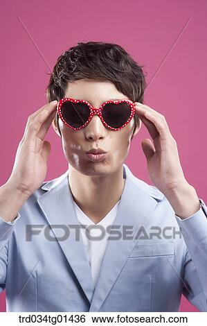 Stock Photograph - A man wearing the heart shaped glasses. Fotosearch